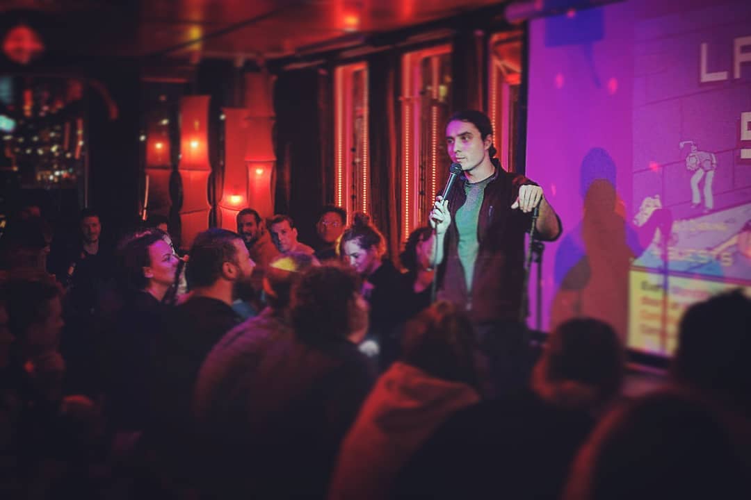 Dragos on stage in front of a full room